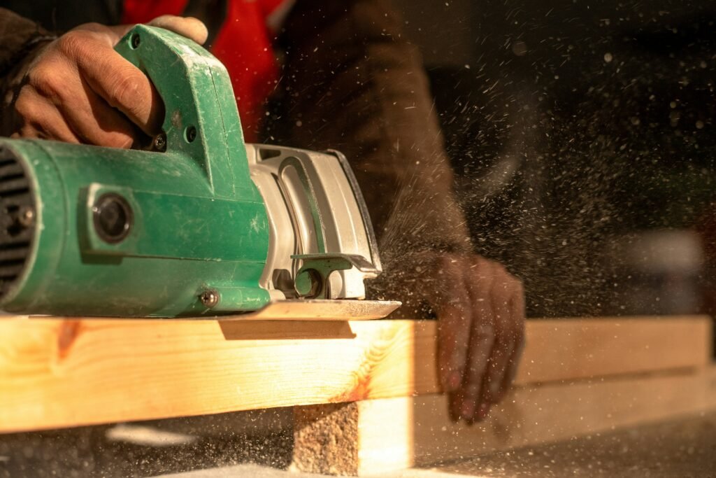 A man using a circular saw to cut a piece of wood